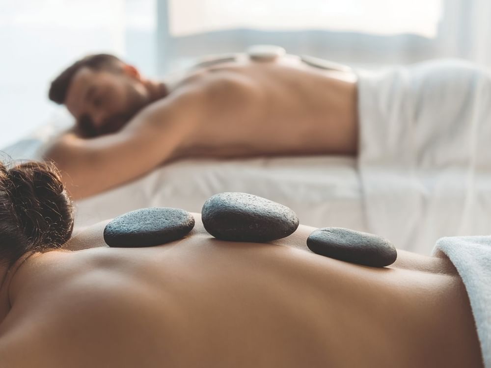 Pareja disfrutando un relajante masaje con piedras calientes en Spa Funeeq Punta Cana de Fiesta Americana Funeeq