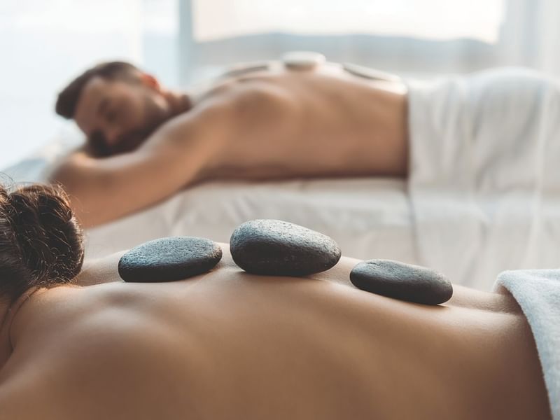 Pareja disfrutando un relajante masaje con piedras calientes en Spa Funeeq Punta Cana de Fiesta Americana Funeeq