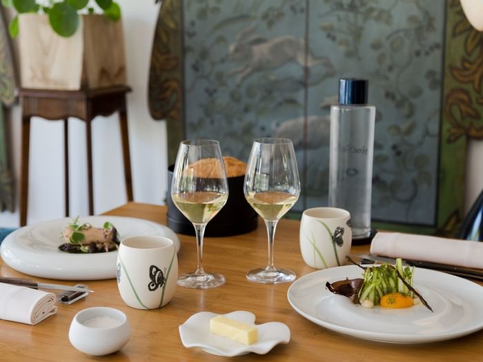 A dining table with dishes & champagne at Originals Hotels