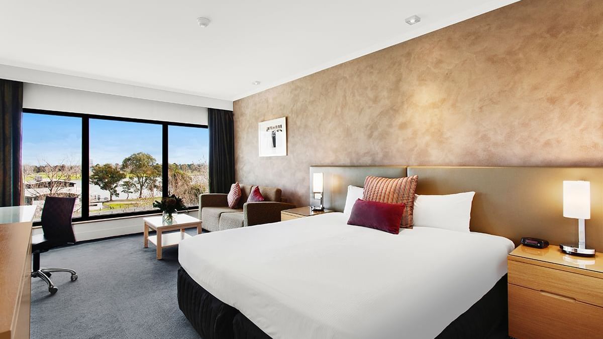 King bed and seating in Mercure Privilege Lakeview Room at Pullman Albert Park