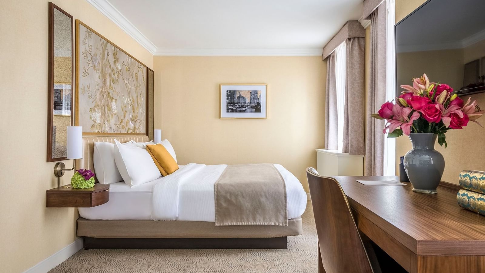 Executive King with a striped bed, floral art, and a wooden desk at Warwick Allerton Chicago