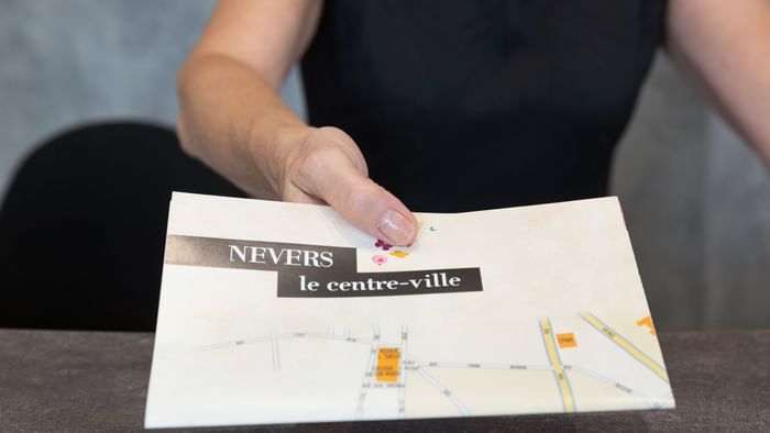 Close up on a lady giving a file at Hotel Nevers Centre Gare