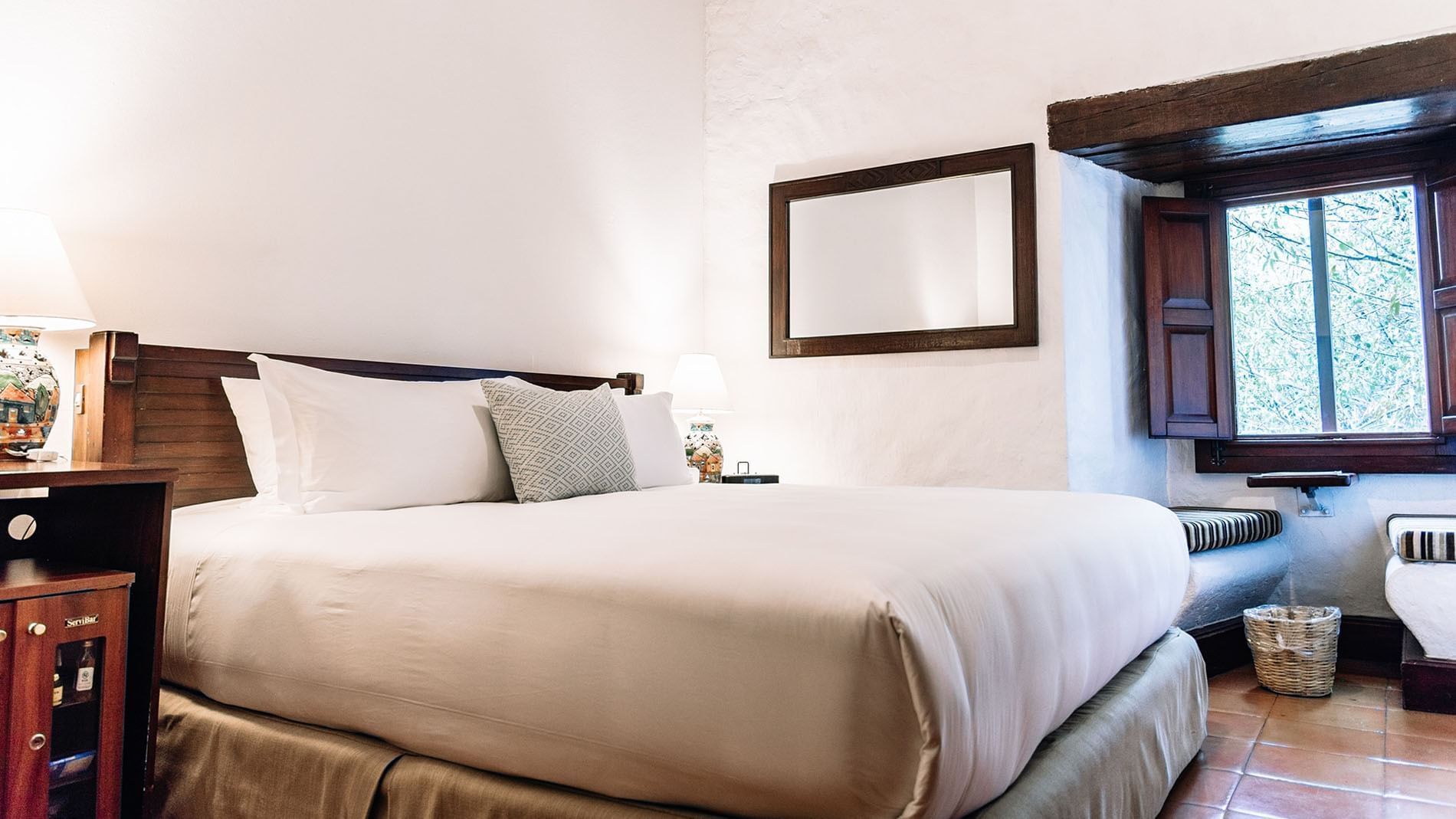 Nook and nightstand by the cozy bed in the King Novicia Suite at Quinta Real Oaxaca