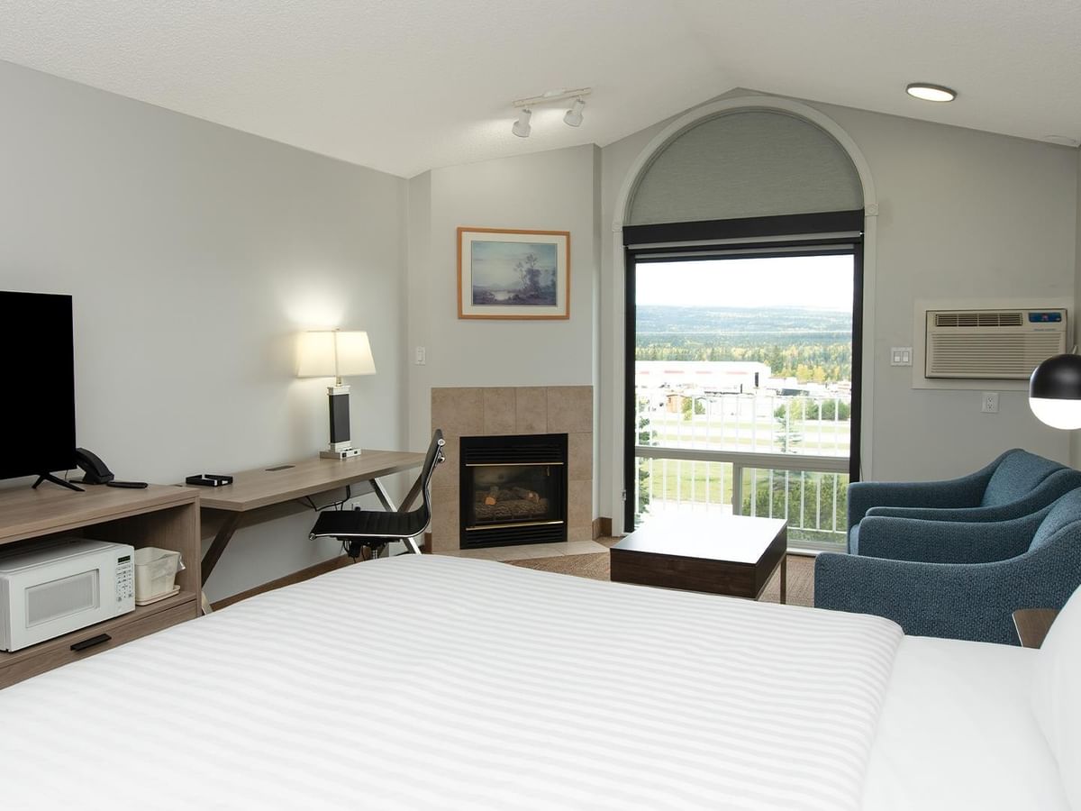 Coast King room with king bed, fireplace, and arched window.
