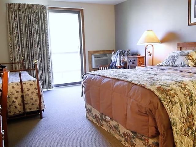 The Pineys interior featuring a large bed and a smaller twin bed, with a window at The Ranch at UCross
