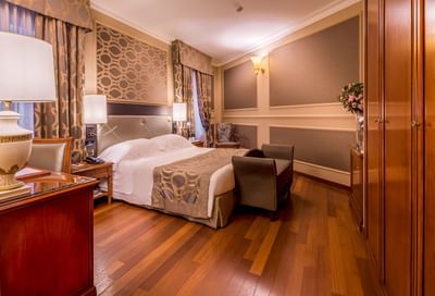 Large bed, cupboard, fresh flowers & lamps in the Family room at Grand Visconti Palace