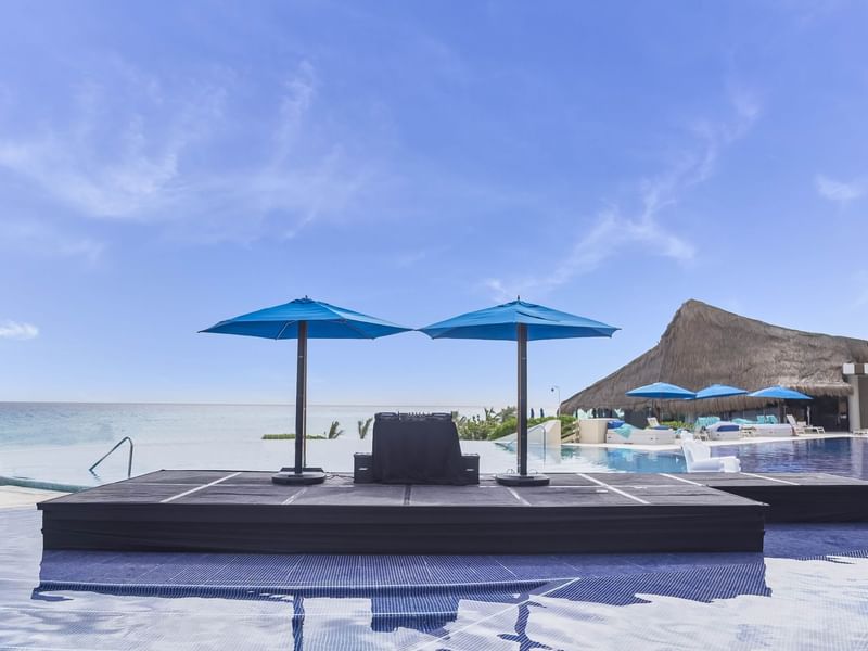 Loungers and sunbeds arranged by the pool overlooking the sea at Live Aqua Resorts and Residence Club