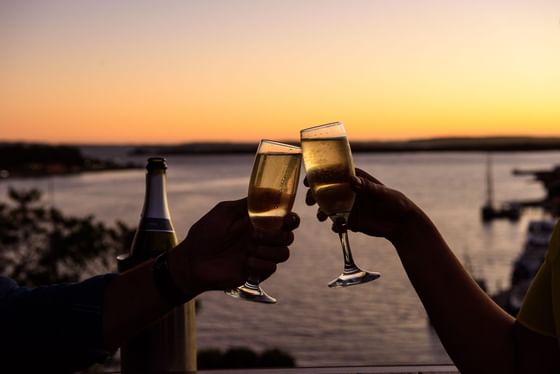 Closeup on toasting 2 champagne glasses at Strahan Village