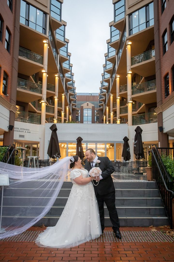 Wedded couple posing by a stairway at Amora Hotel Melbourne