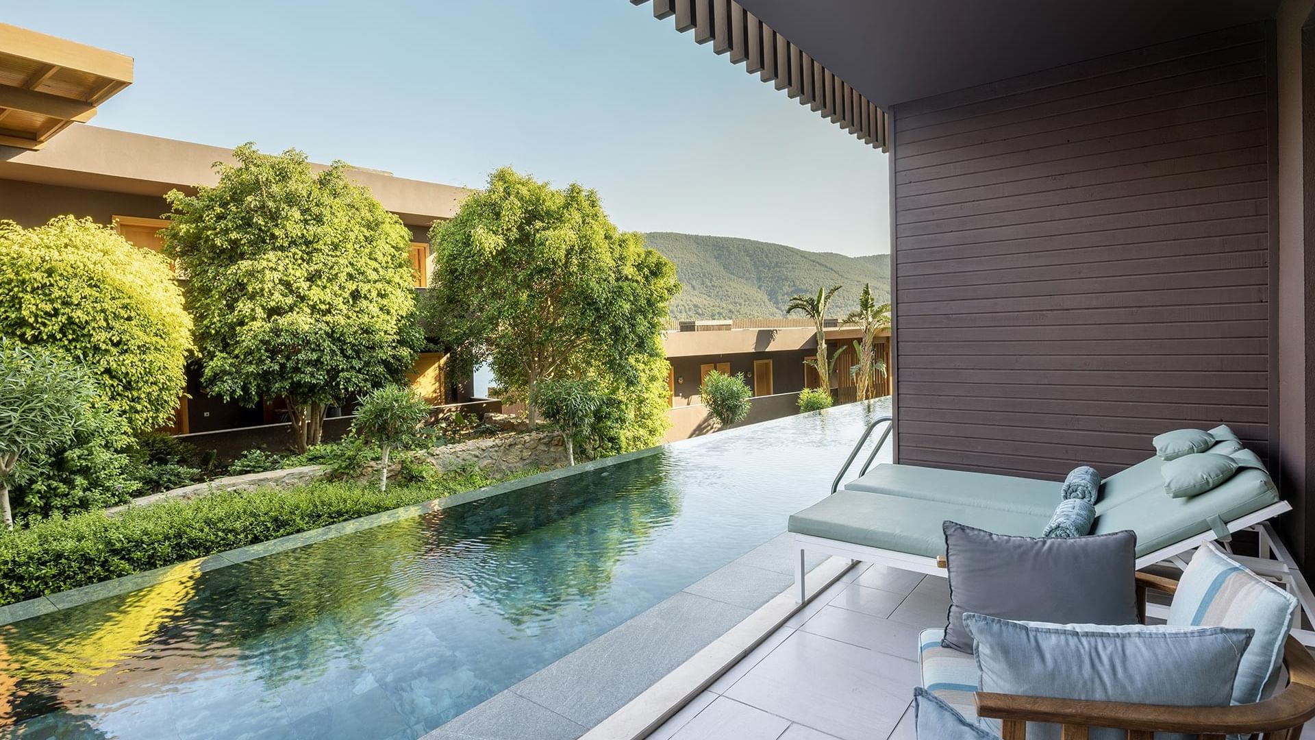 Бассейн, шезлонги и вид на сад у номера Swim-up Superior в отеле Titanic Luxury Collection Bodrum.