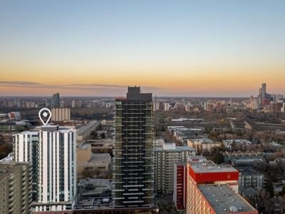 A white-coloured tower with a location marker contrasts with the city of Edmonton in the background.