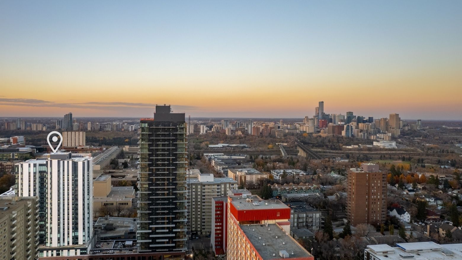 A white-coloured tower with a location marker contrasts with the city of Edmonton in the background.