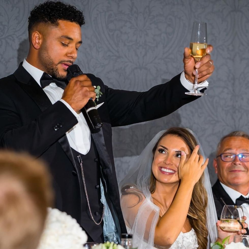 groom raising a toast to his new wife at easthampstead park