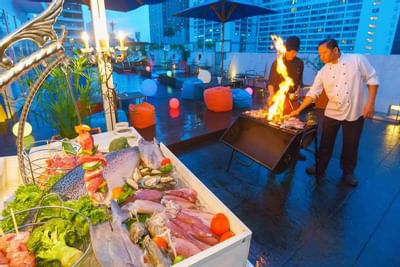 Men set BBQ near the swimming pool at Dream Thailand Bangkok
