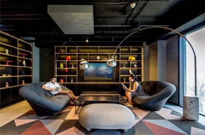 Couple relaxing while reading books in the Lounge area with a view of the mountains at Hotel Nodo