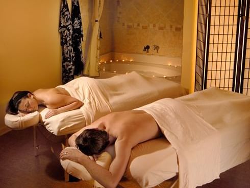 Couple relaxing on massage tables at August Moon Spa
