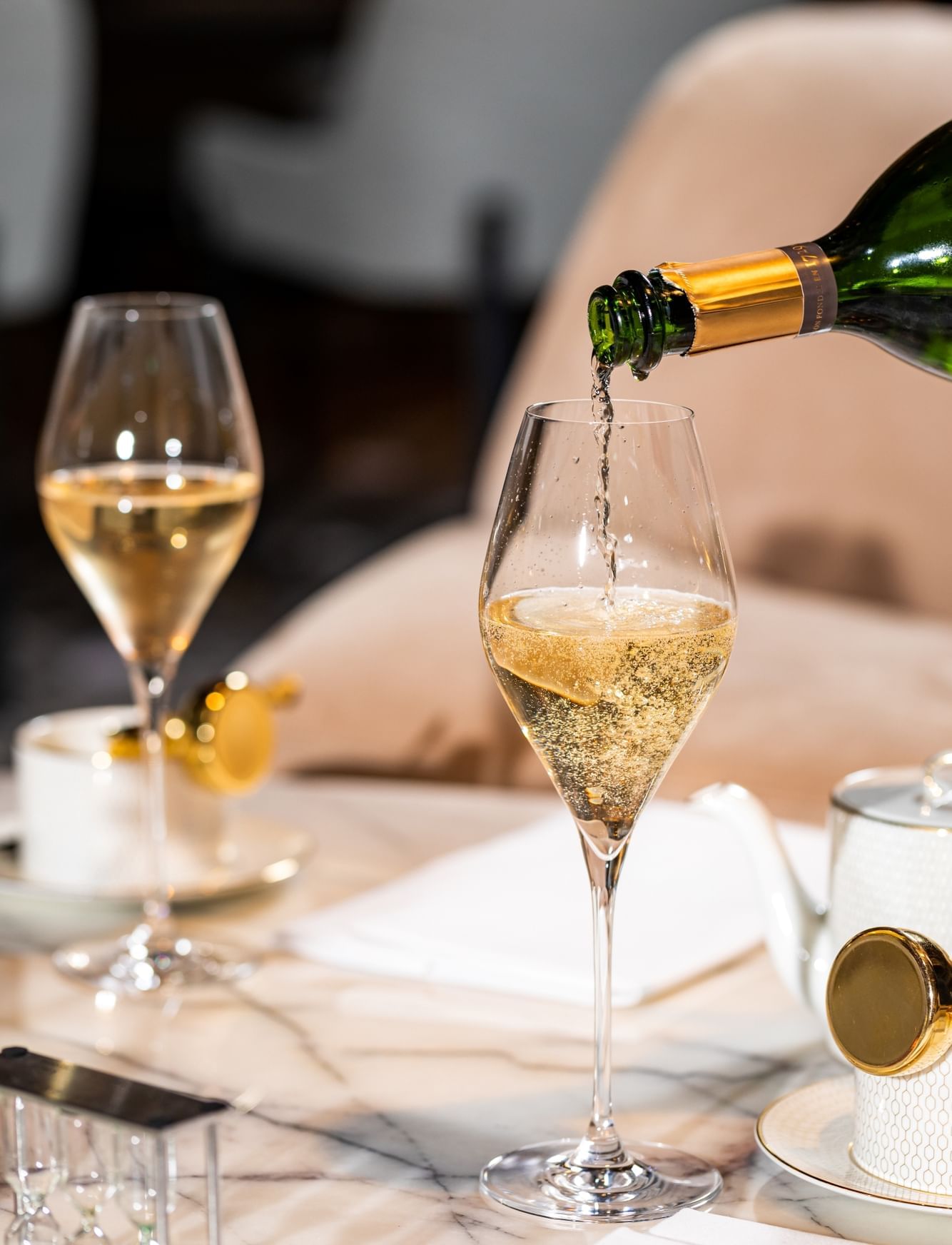 Close-up of fizzy champagne poured into a wine glass at The Londoner Hotel