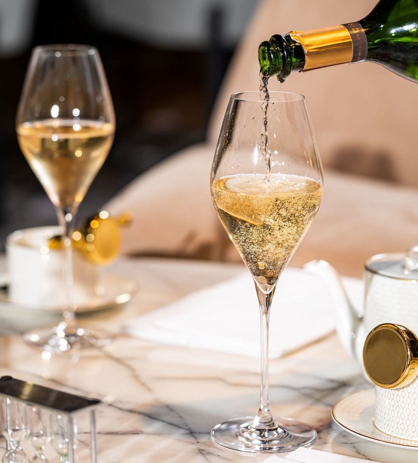 Close-up of fizzy champagne poured into a wine glass at The Londoner Hotel