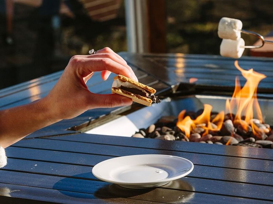 Woman holding a biscuit near fireplace at Heritage House Resort
