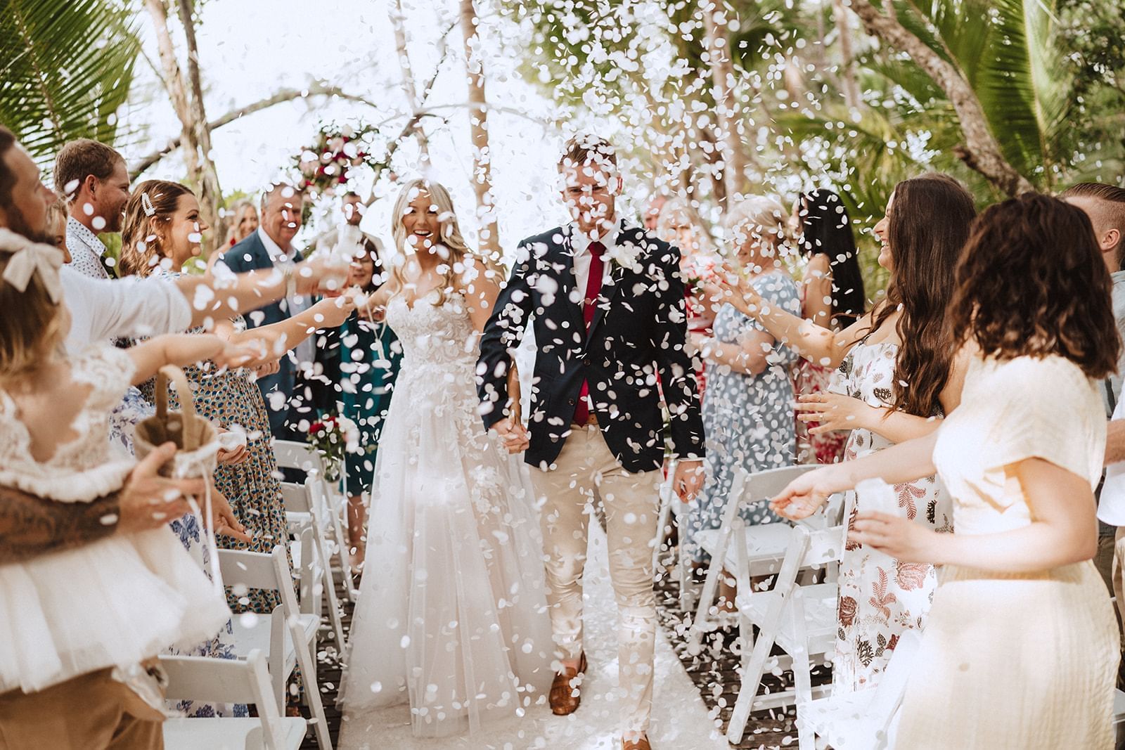Wedding guests throwing flower petals on bride and groom in Boardwalk at Pullman Port Douglas Sea Temple Resort & Spa