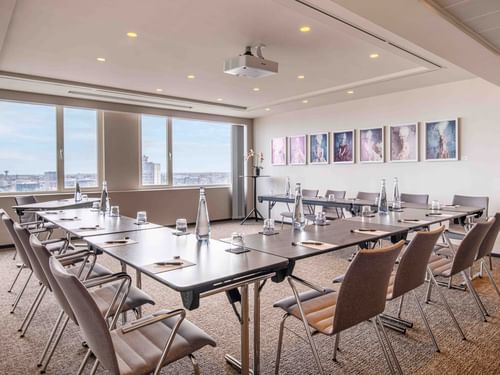 Meet 25 Two Meeting room with large windows, artwork on the wall, and arranged tables and chairs at The Hotel Brussels