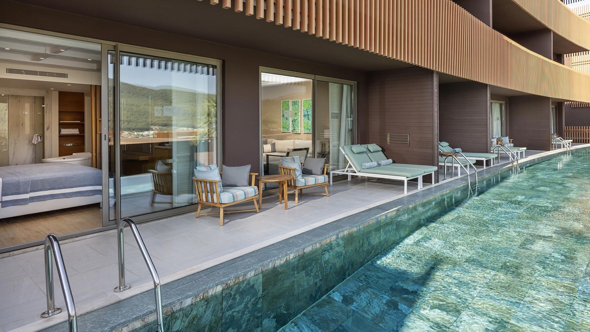 Lounge area by the pool in Swim-up Deluxe Room at Titanic Luxury Collection Bodrum
