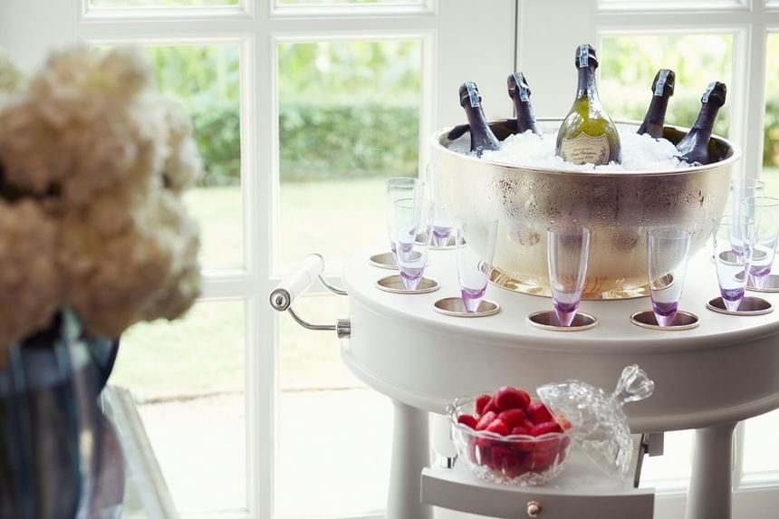 Elegant champagne bucket filled with ice and bottles, surrounded by glasses and fresh strawberries at Park Hyatt Saigon