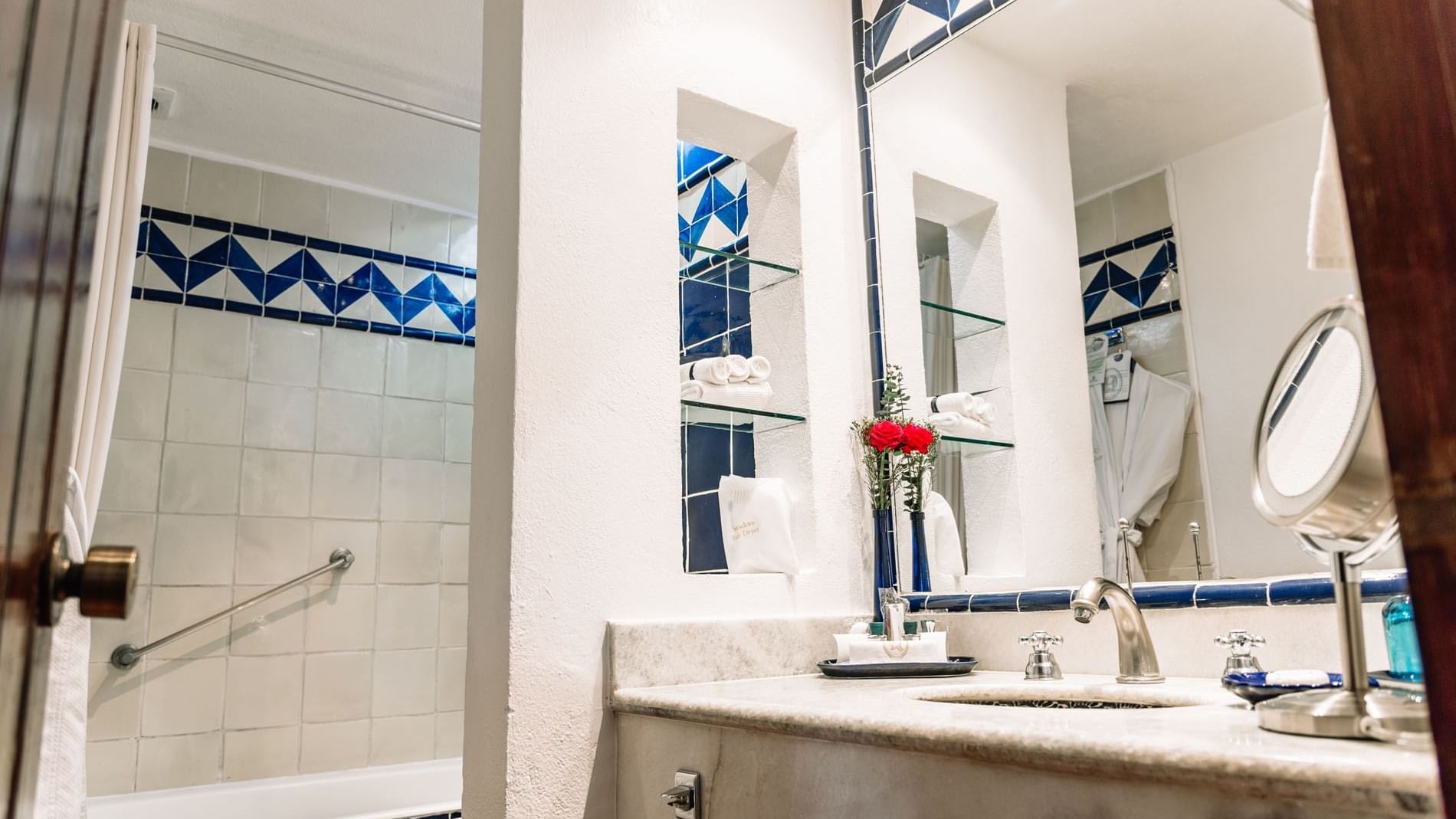 Bathroom counter with a large mirror and bathtub in the King Grand Class Suite at Quinta Real Oaxaca
