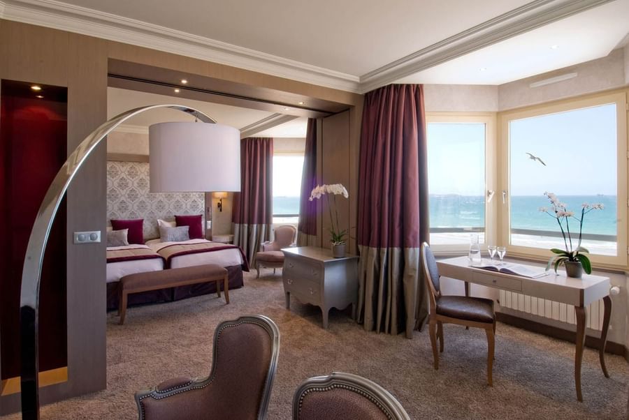 Interior of a Suite featuring carpeted floors & twin beds with Sea view at Le Grand Hôtel des Thermes