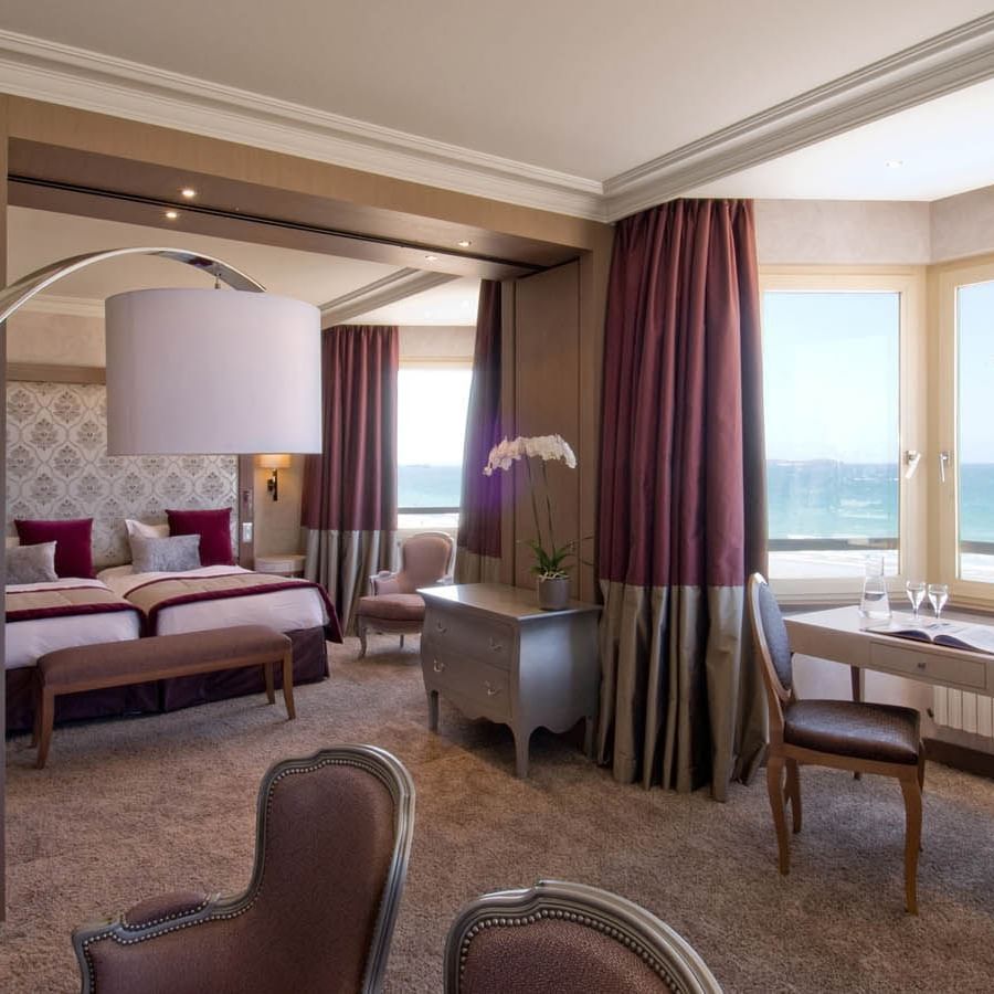 Interior of a Suite featuring carpeted floors & twin beds with Sea view at Le Grand Hôtel des Thermes
