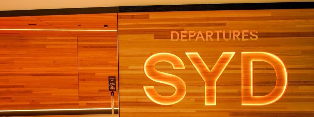 Glowing orange SYD departures sign adding a modern touch at Novotel Sydney International Airport