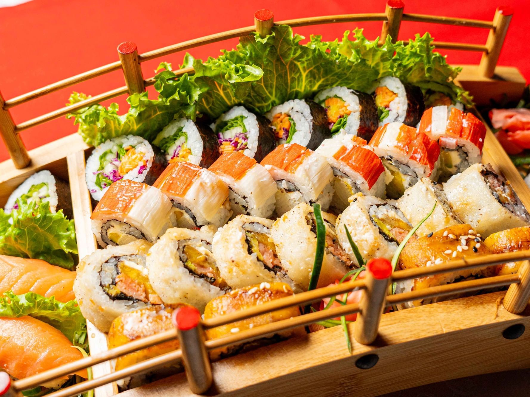 Wooden sushi boat with various sushi rolls and sashimi, served at the Nori Sushi Bar in Panama.