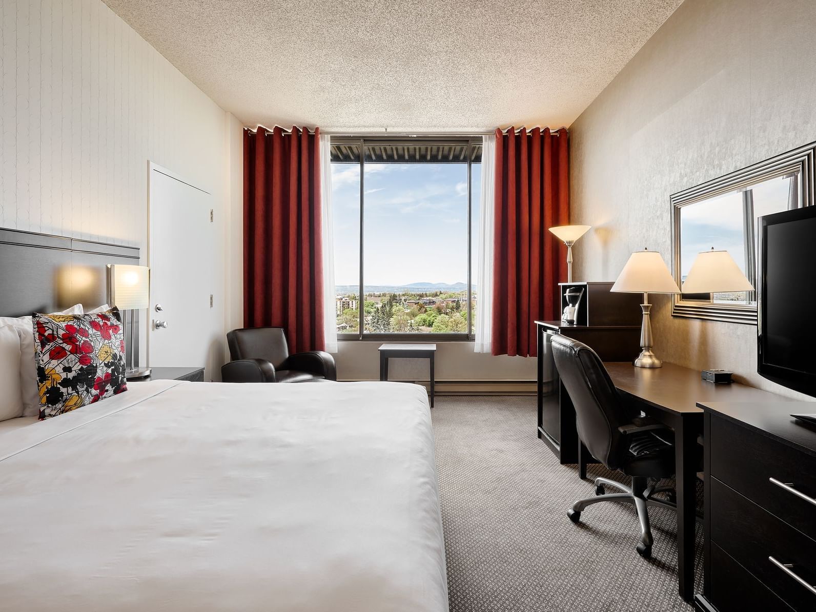 Working table with window view in Signature Room, King Size Bed at Travelodge Hotel & Convention Center Québec City