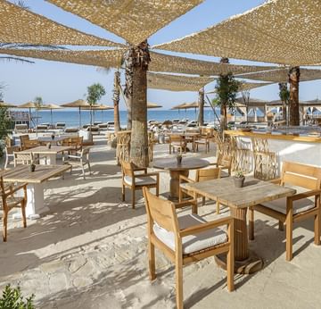 Las Bachas dining area with tables, chairs, canopy, and beach view in Cullinan Belek