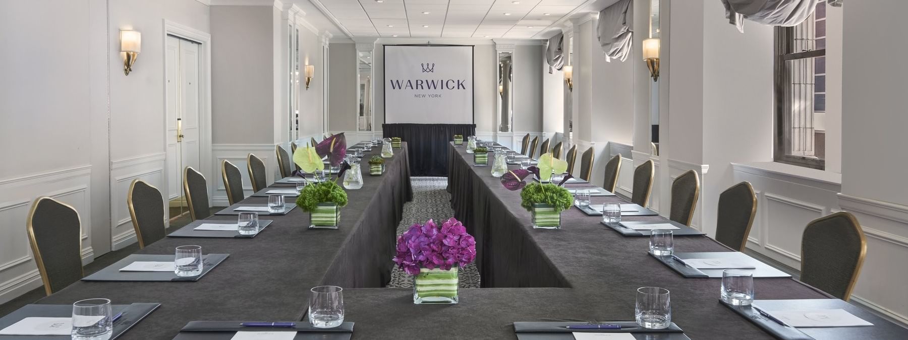 U-shaped conference table with black chairs and centerpieces in Essex meeting room at Warwick New York