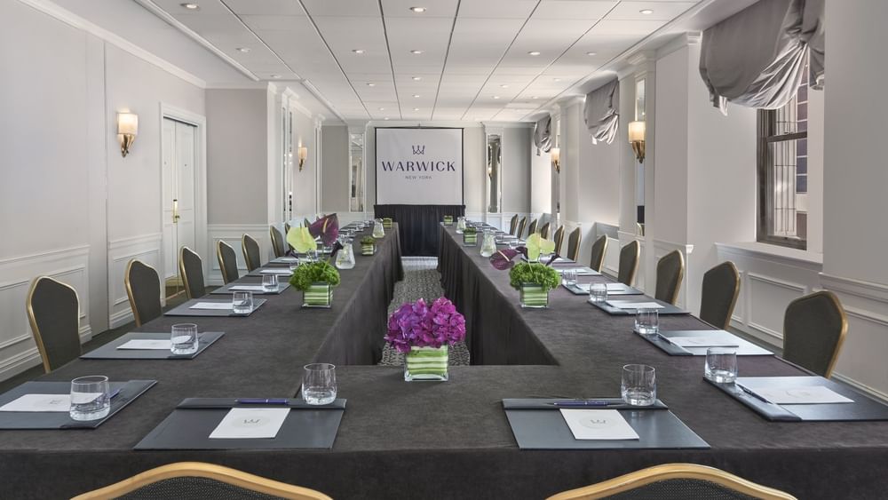 U-shaped conference table with black chairs and centerpieces in Essex meeting room at Warwick New York