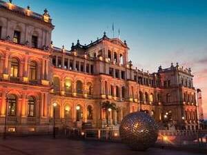 The brightly lit historic Star Casino building in Brisbane at sunset, with a large metallic sculpture near The Sebel Brisbane