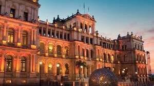 The brightly lit historic Star Casino building in Brisbane at sunset, with a large metallic sculpture near The Sebel Brisbane