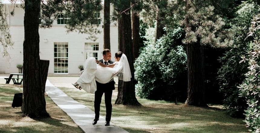 Groom holding his bride in the garden at Gorse Hill