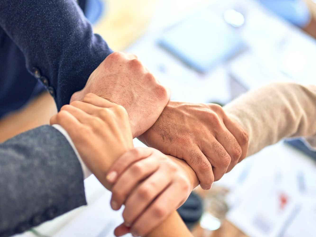 Close-up of interlocked arms symbolizing Teamwork at Saujana Hotel Kuala Lumpur