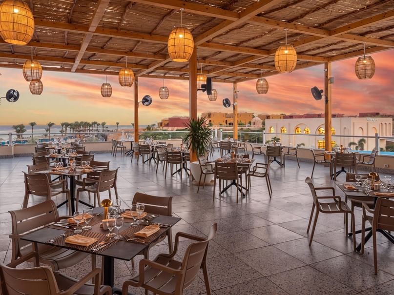 Open-air rooftop dining area with sunset views and woven pendant lights at Pickalbatros Villaggio Resort Portofino Marsa Alam