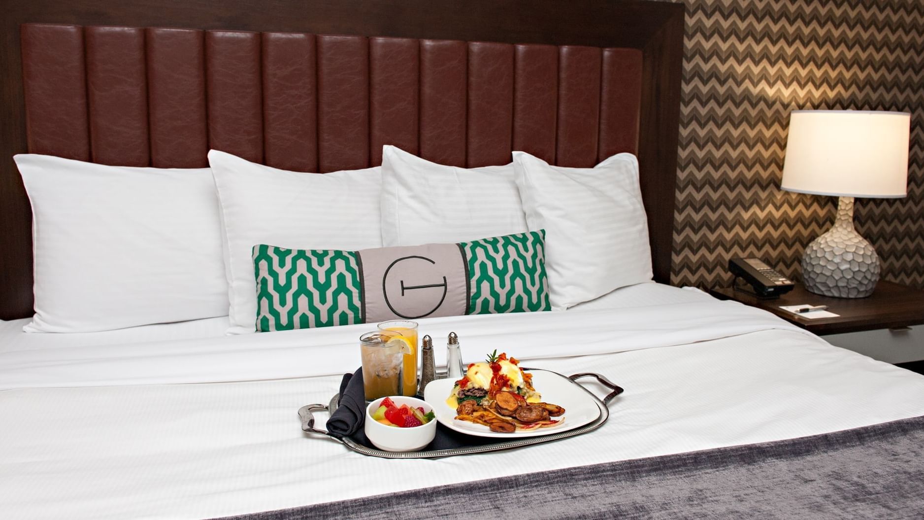 a tray of breakfast on a hotel bed