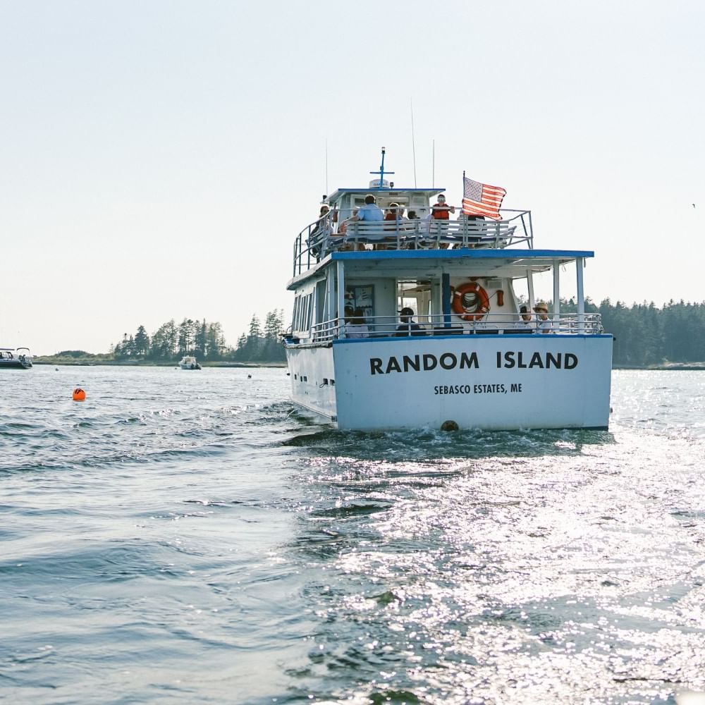 Random Island boat on the ocean at Sebasco Harbor Resort by Ogunquit Collection