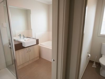 Clean bathroom with shower, sink, and toilet in a hotel room.