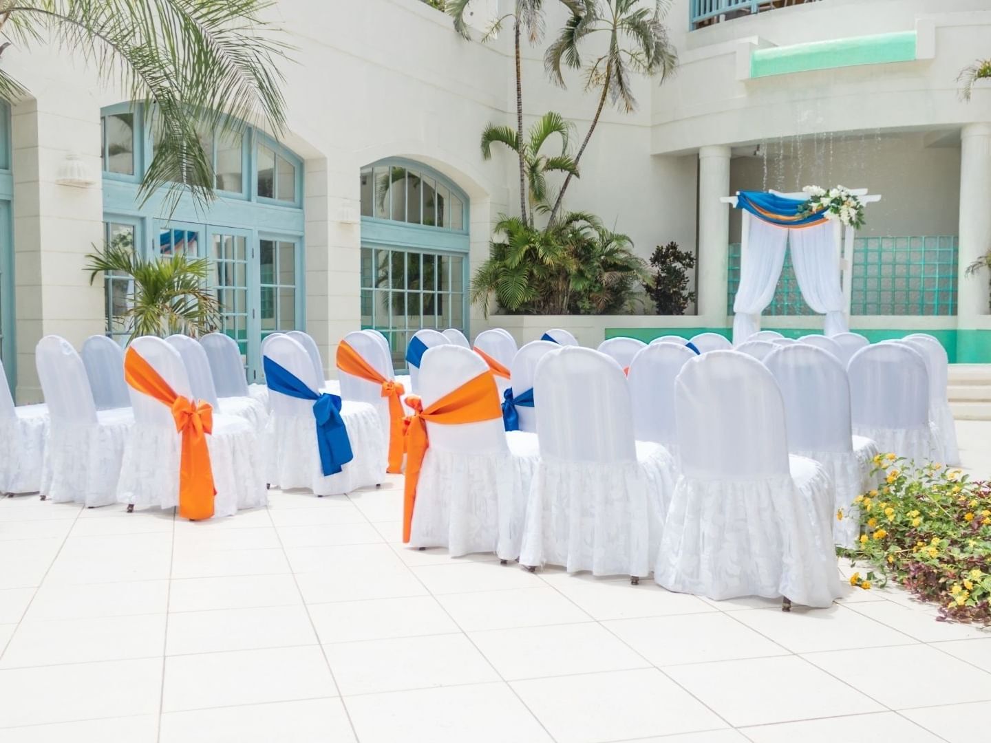 Decorated white chairs and a ceremony setup at Savannah Beach Hotel.