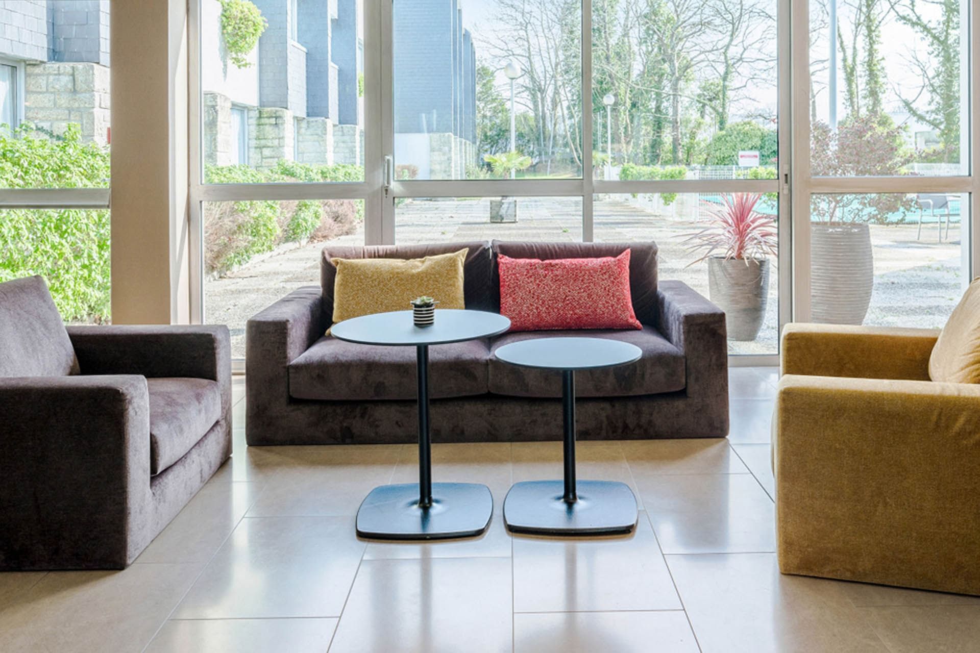 Coin salon du hall avec vue sur la piscine à l'Oceania Quimper