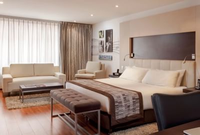 Dormitorio y sala de estar en una suite en hoteles  Bluedoors