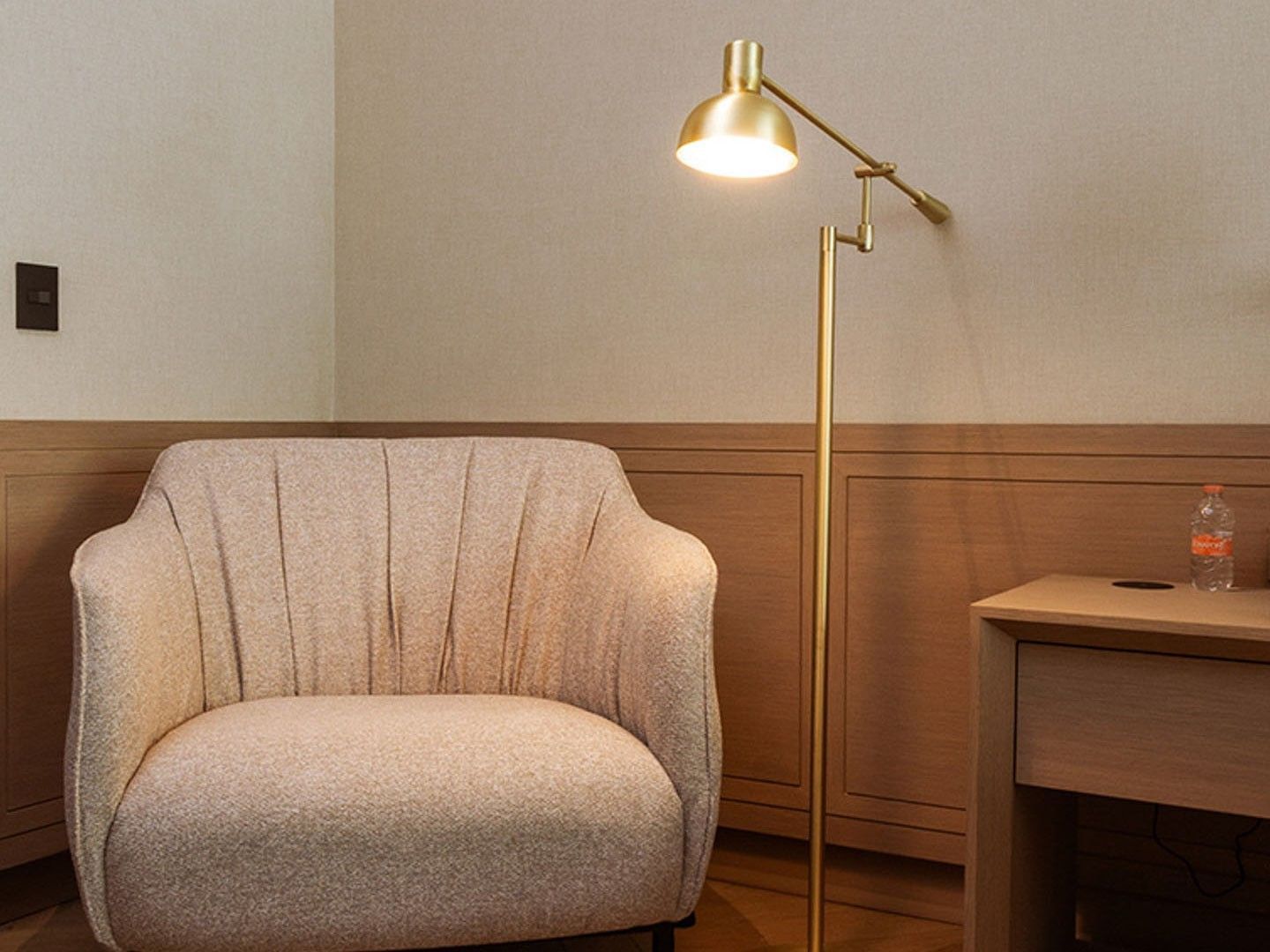 King Superior Viceroys Suite seating area with a beige armchair and a gold floor reading lamp at Camino Real Polanco Mexico