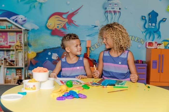 Two children with art supplies playing on the table in Kids' Club at The Diplomat Resort