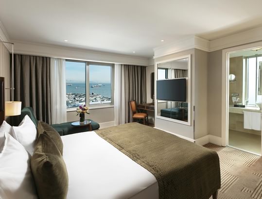Titanic Port Bakırköy’de, geniş pencerelere, deniz manzarasına, king-size yatağa, çalışma masasına, koltuğa ve ferah bir banyoya sahip Deluxe oda.